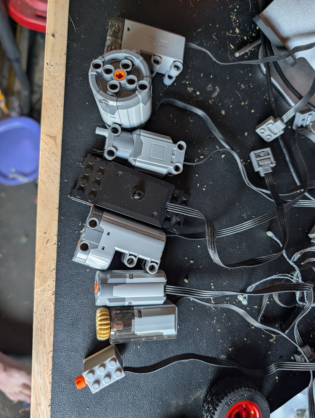 Salvaged Lego Technic motors, gears and a Cada servo laid out on a workbench